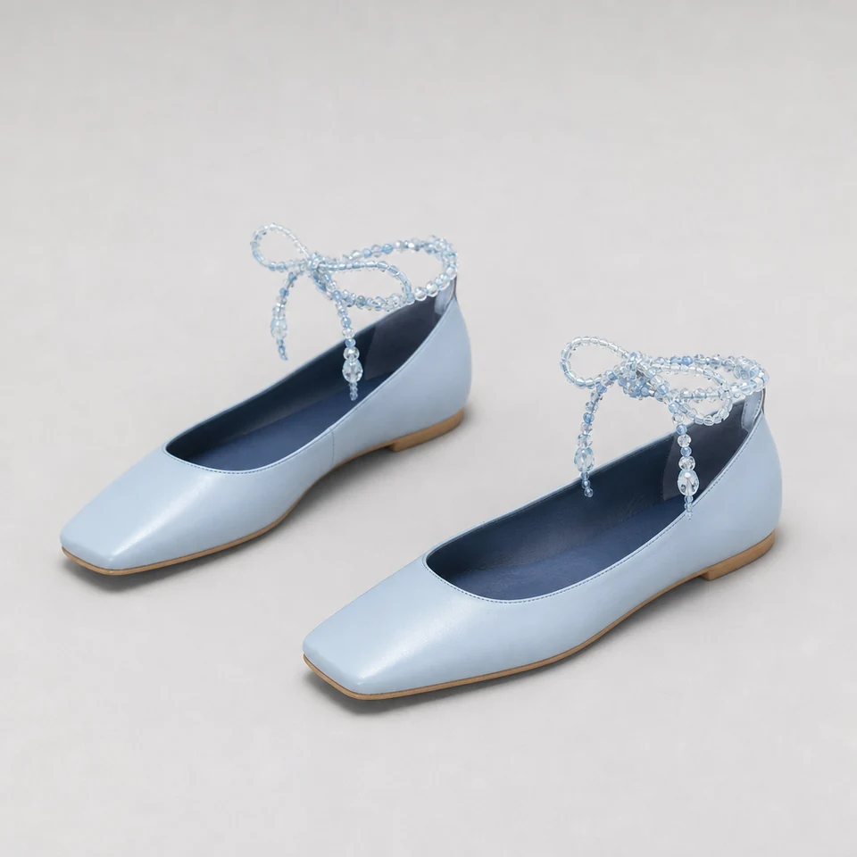 Light blue flat shoes with square toes and glossy beaded ankle tie closures
