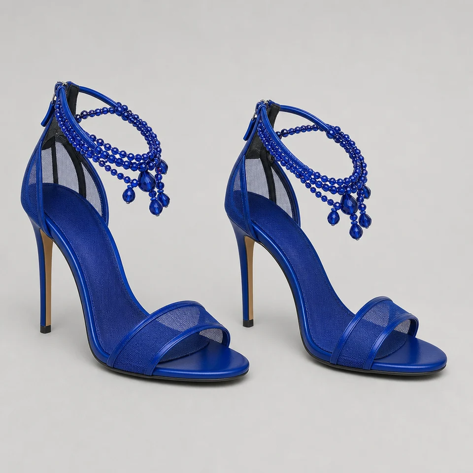 Pair of blue high-heeled sandals with open toes, mesh panels, and decorative beaded ankle straps