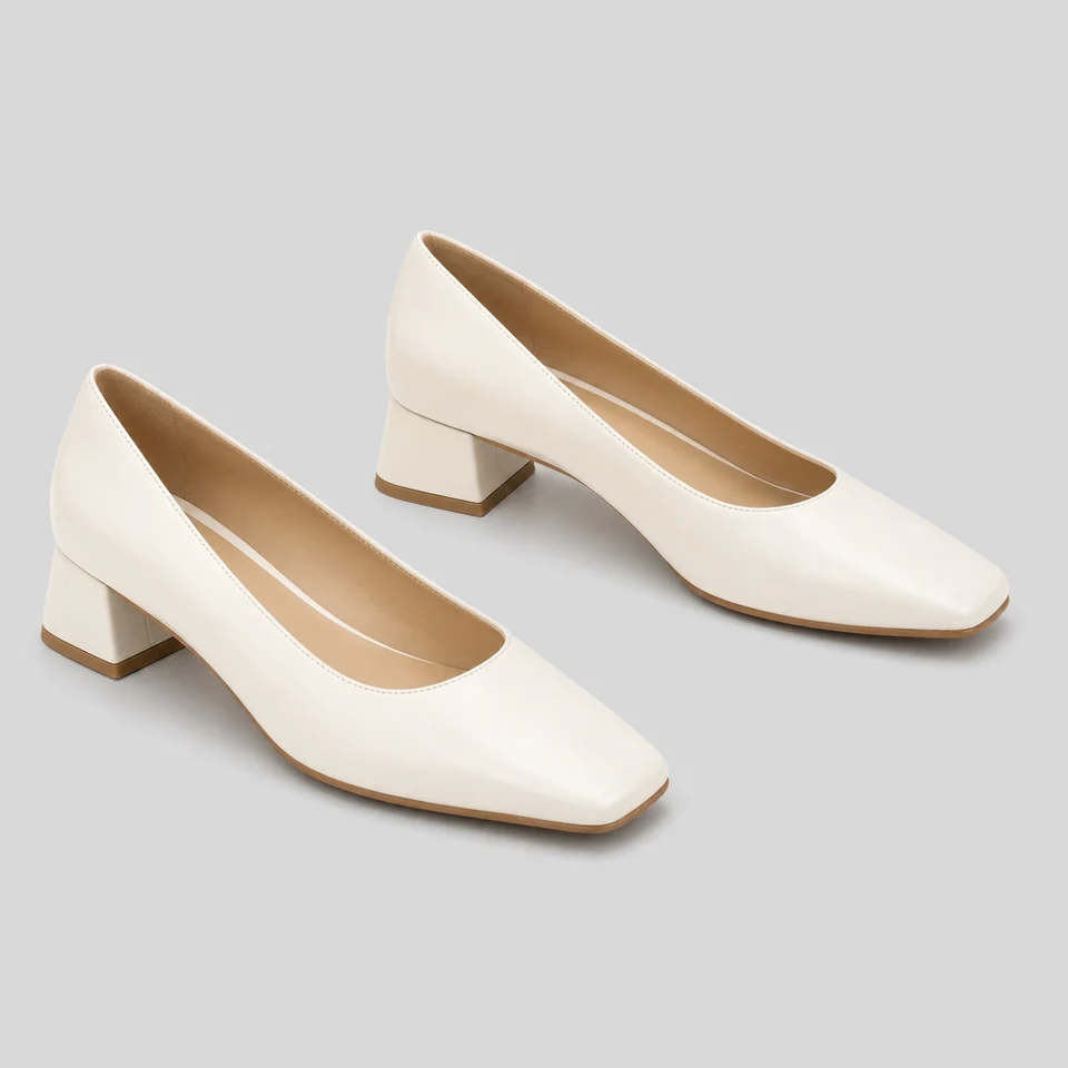 Pair of white block heel pumps with square toes in smooth matte white-look material